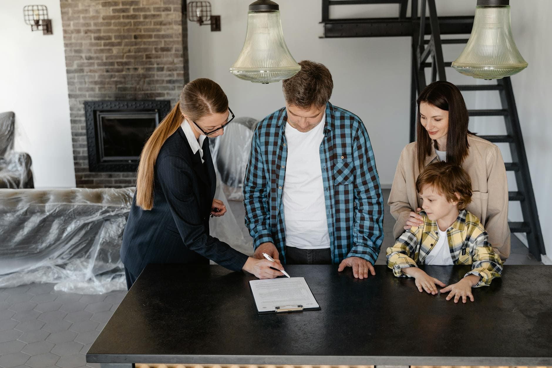 An adviser going over paperwork at a table with a family in their home