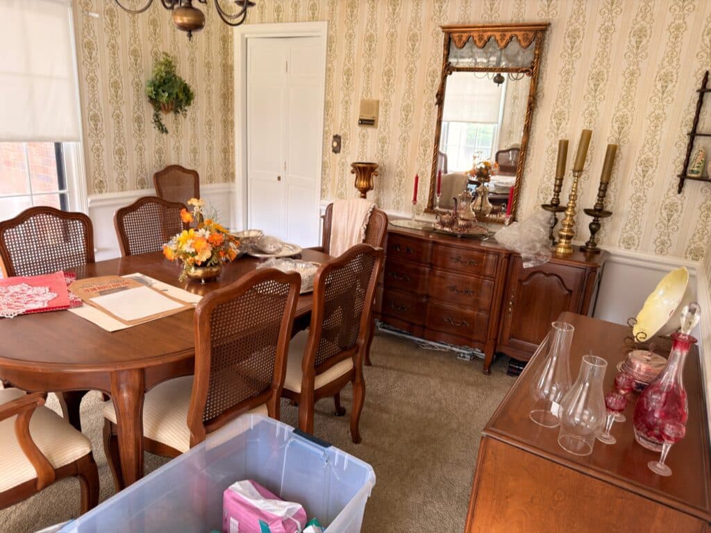 Dining furniture, artwork, and decorative pieces arranged throughout a real Estate Greats sale