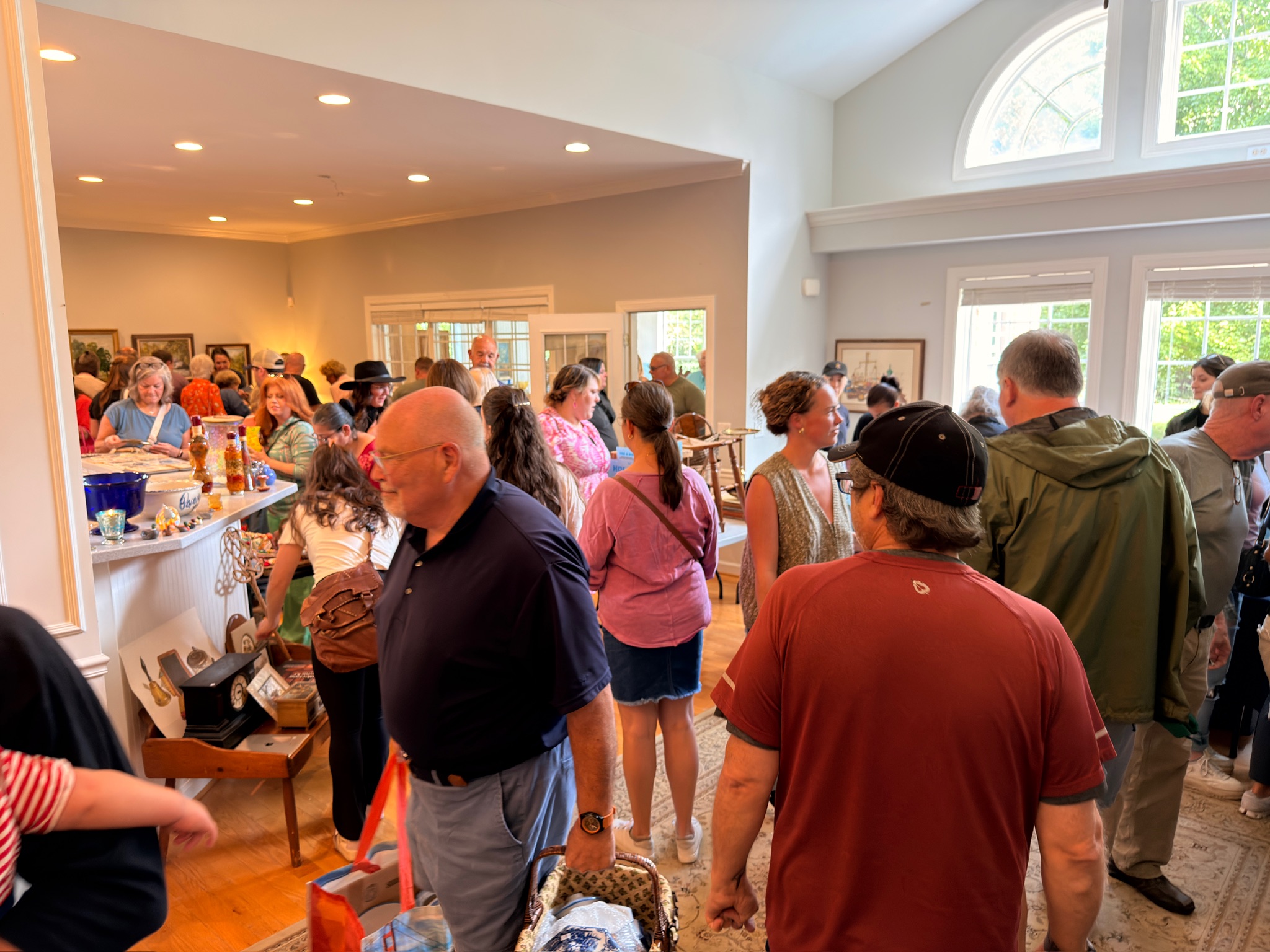 A packed living room of shoppers at a busy Estate Greats sale